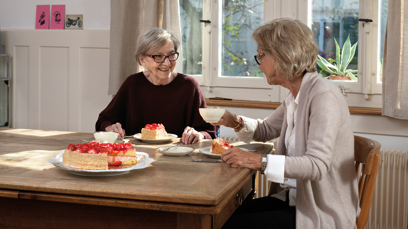 Zwei Seniorinnen zu Hause bei KAffee und Kuchen