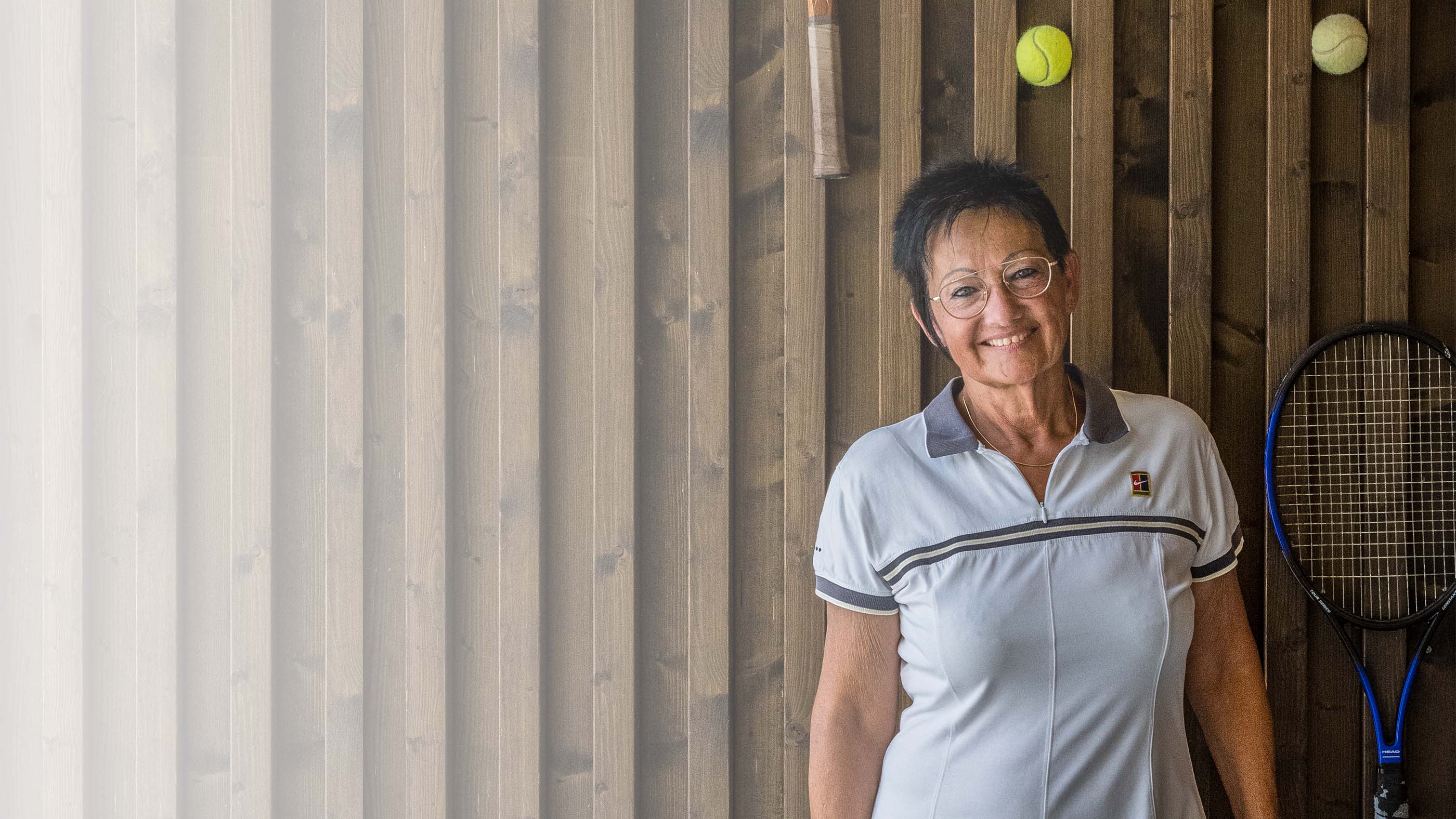 lachende gepflegte Seniorin im Tennisdress